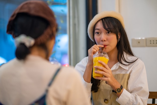 asian woman friends sitting by the window in cafe