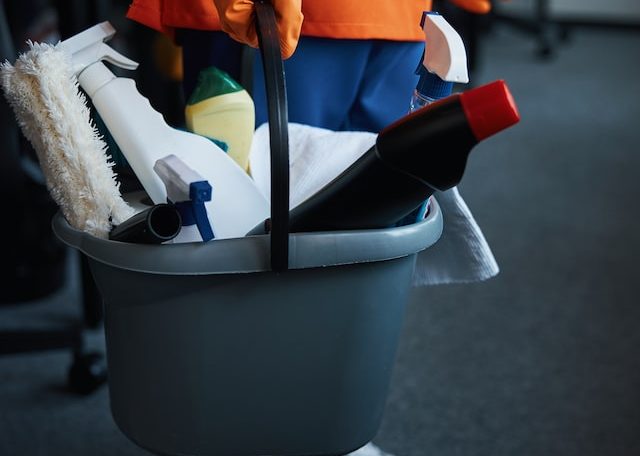 female cleaner holding a plastic bucket