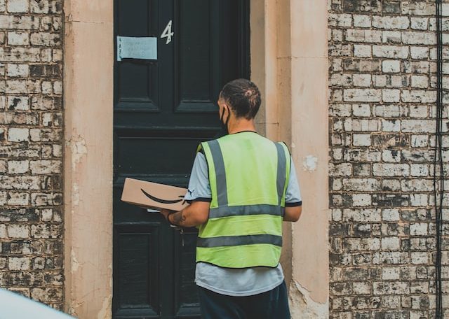 man in green striped shirt holding parcel