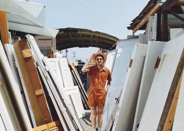 person standing beside white wooden panels